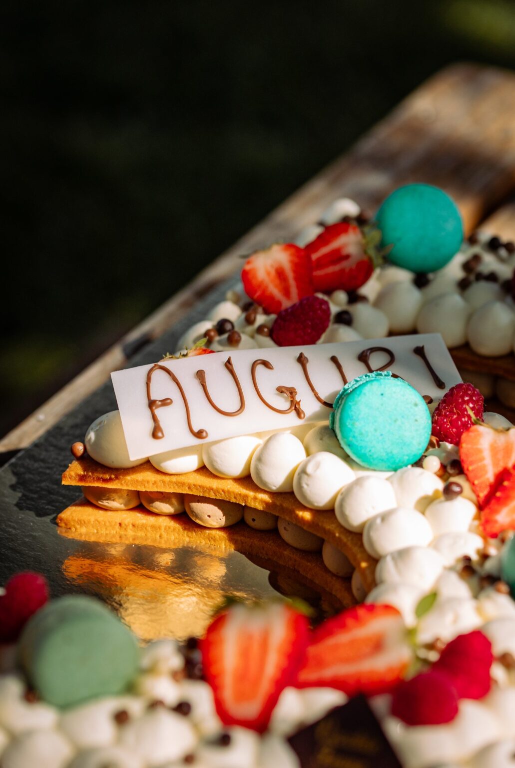 Scritta Auguri sulla Creme Tarte con macarons e fragole