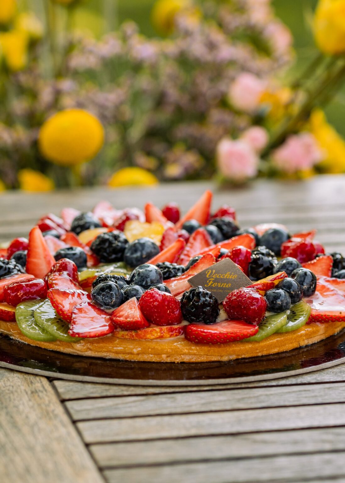 Crostata di frutta con frutti di bosco, fragole e kiwi