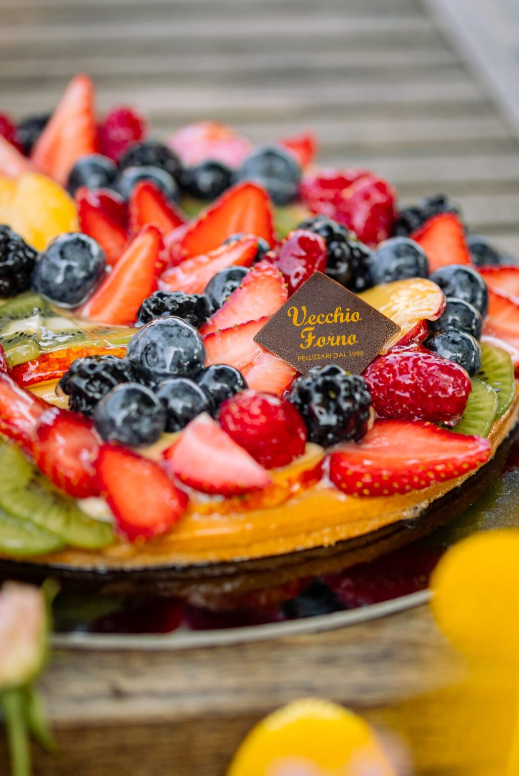 Crostata di frutta vista di tre quarti con placchetta Vecchio Forno