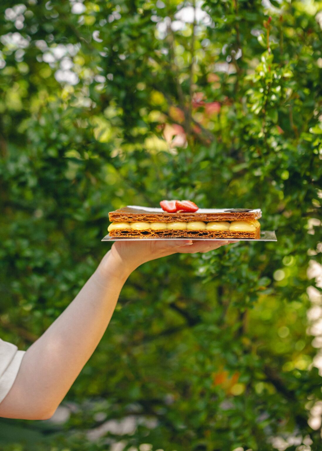 Millefoglie rettangolare con crema pasticcera e fragole, servita su un vassoio