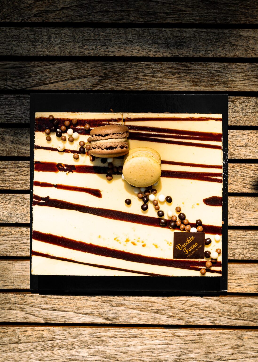Semifreddo quadrato glassato con righe di cioccolato, macarons e perle di cioccolato