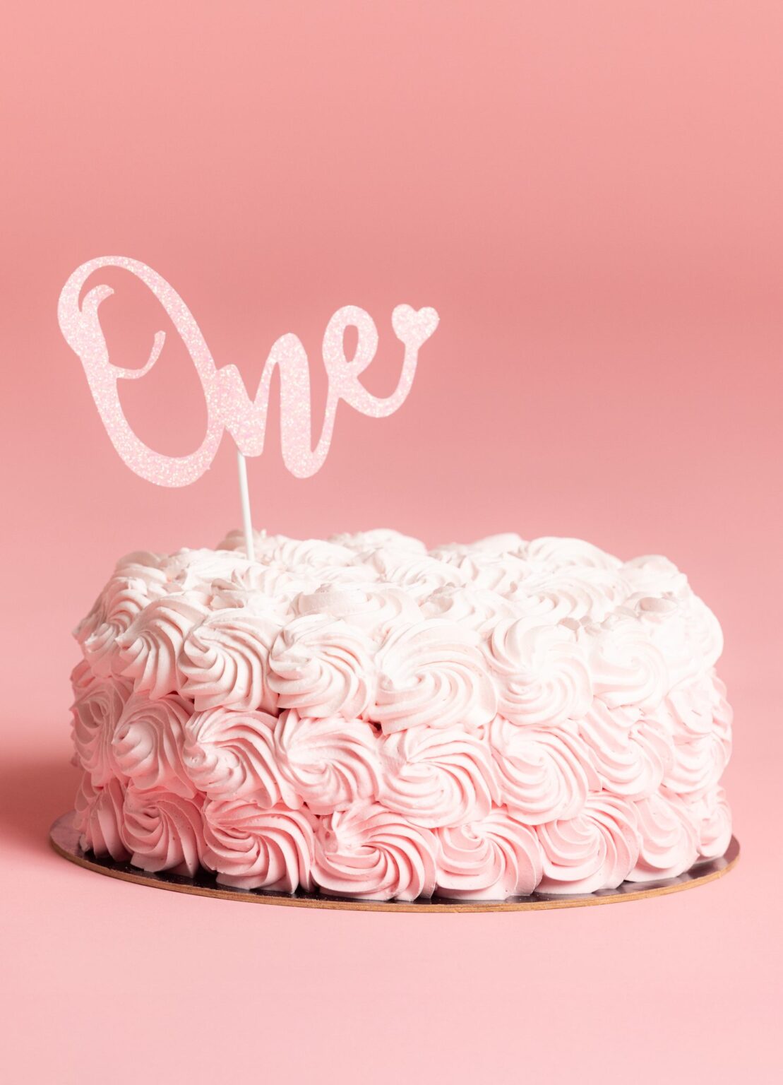 Smash Cake con rose di panna rosa e topper “One”