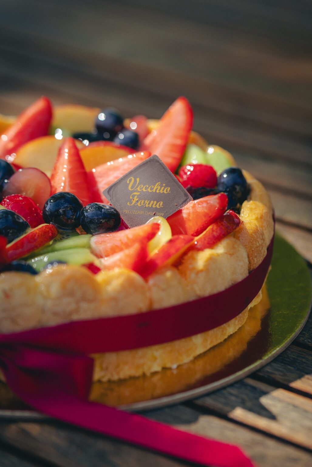 Dettaglio del cornicione di biscotti e della frutta della Torta Charlotte