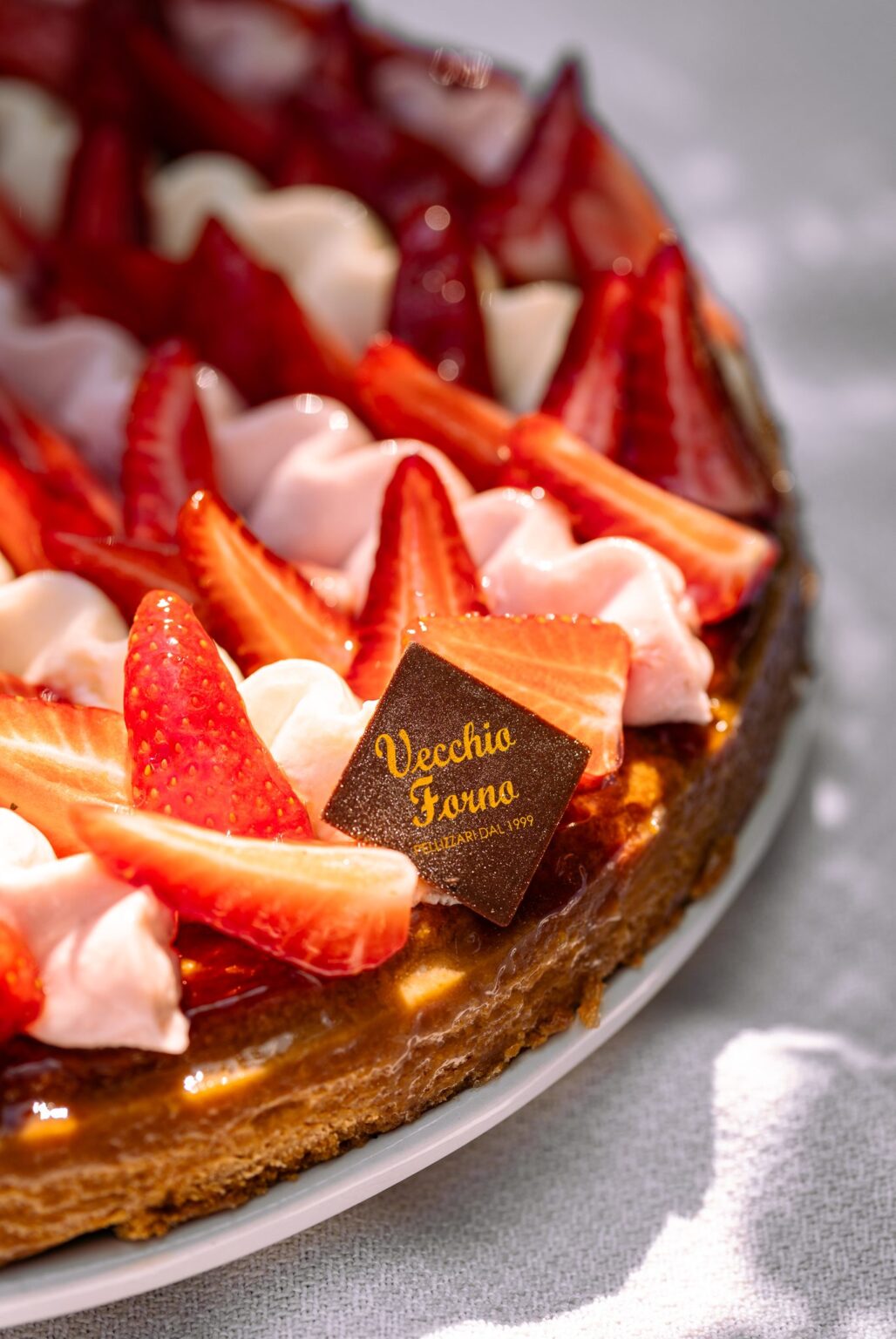 Dettaglio del bordo della Torta Frangipane con fragole e ciuffi di cremoso